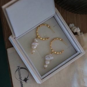 Pendiente dorado con perlas naturales.