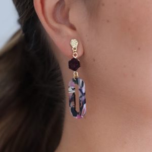 Pendientes dorados de bisutería con tonos granates.