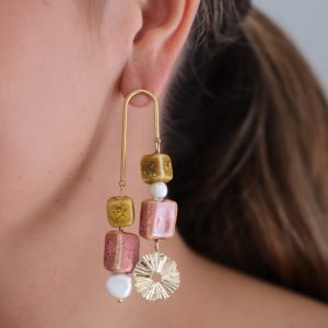 Pendientes largos de bisutería dorados con perlas y piezas de cerámica.