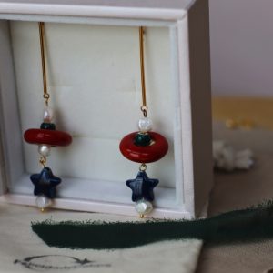 Pendientes dorados largos de cerámica y perlas.